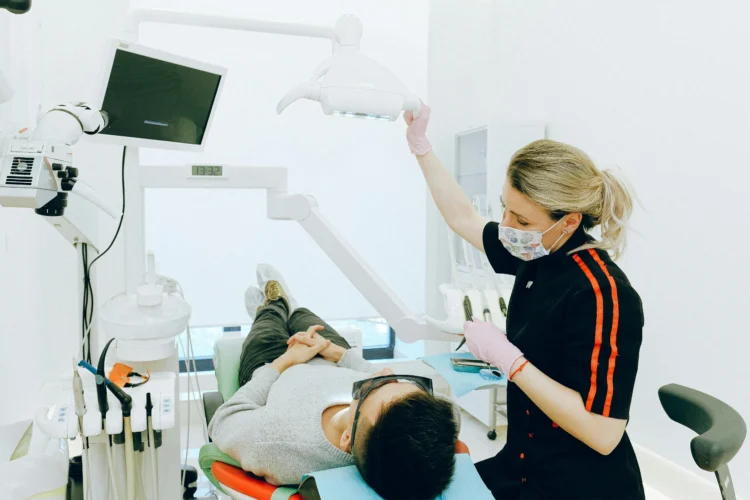 Experienced dental care professionals performing dental check-up on man