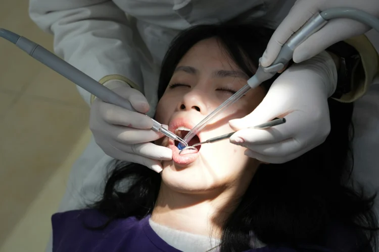 Woman having teeth cleaned by dentist to start her Invisalign treatment