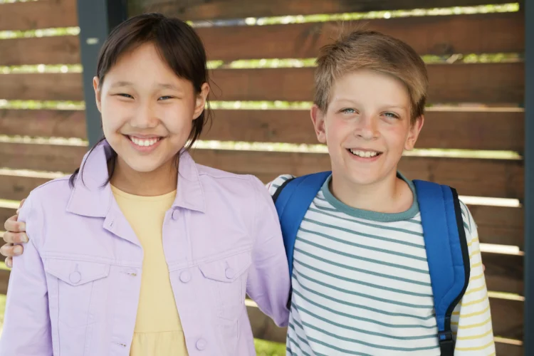 Teens smiling together, showcasing Invisalign aligners