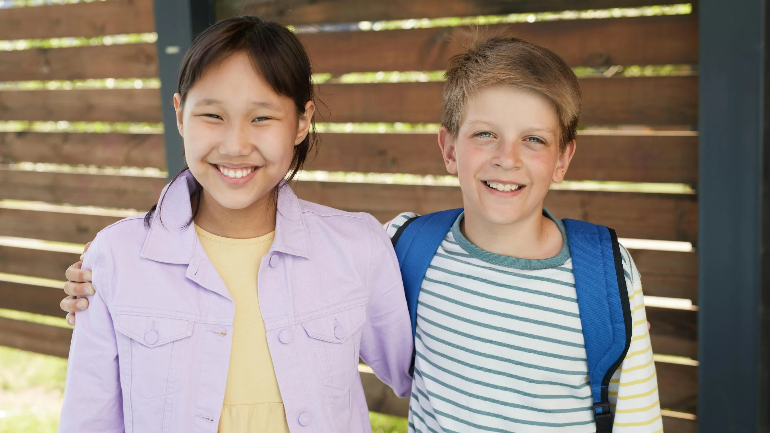 Teens smiling together, showcasing Invisalign aligners