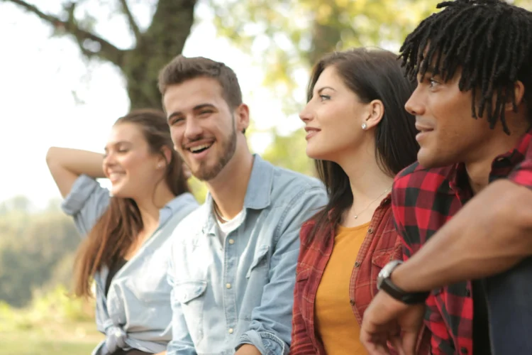 Happy diverse couples enjoying a pain-free dental implants experience in the park