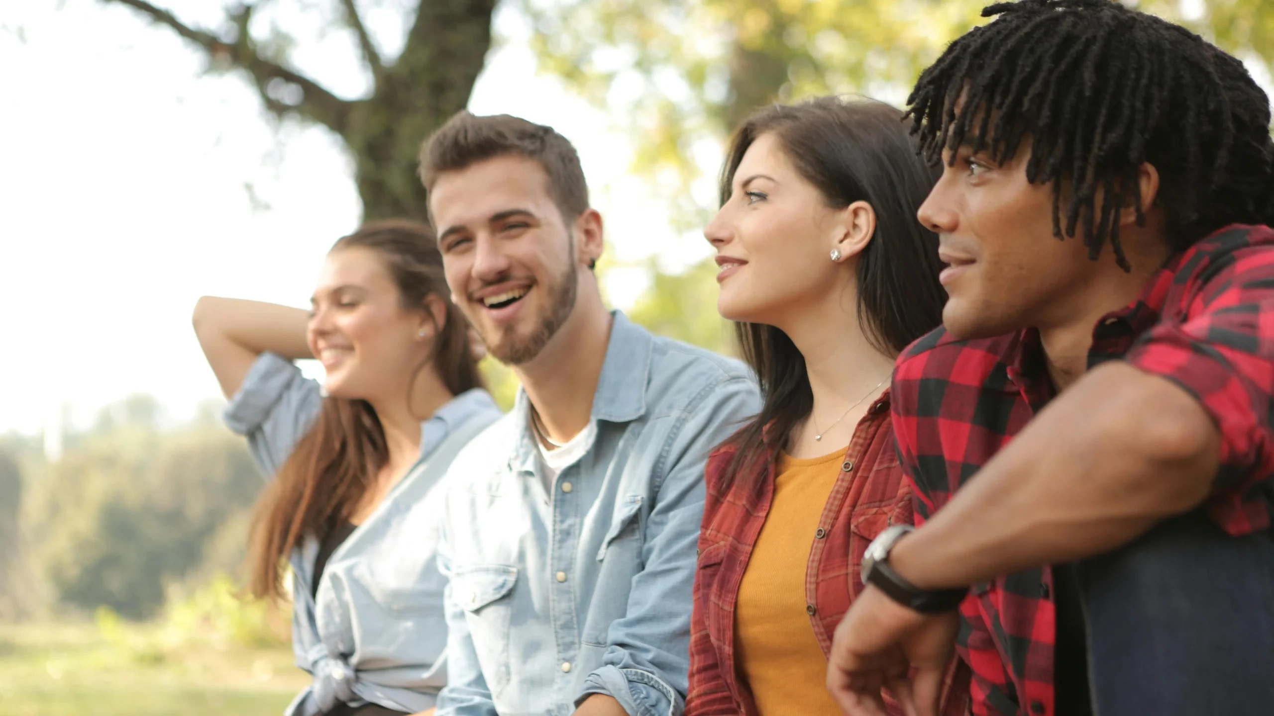 Happy diverse couples enjoying a pain-free dental implants experience in the park