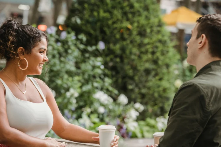 Cheerful couple enjoying coffee break together, representing cosmetic dental enhancements benefits.