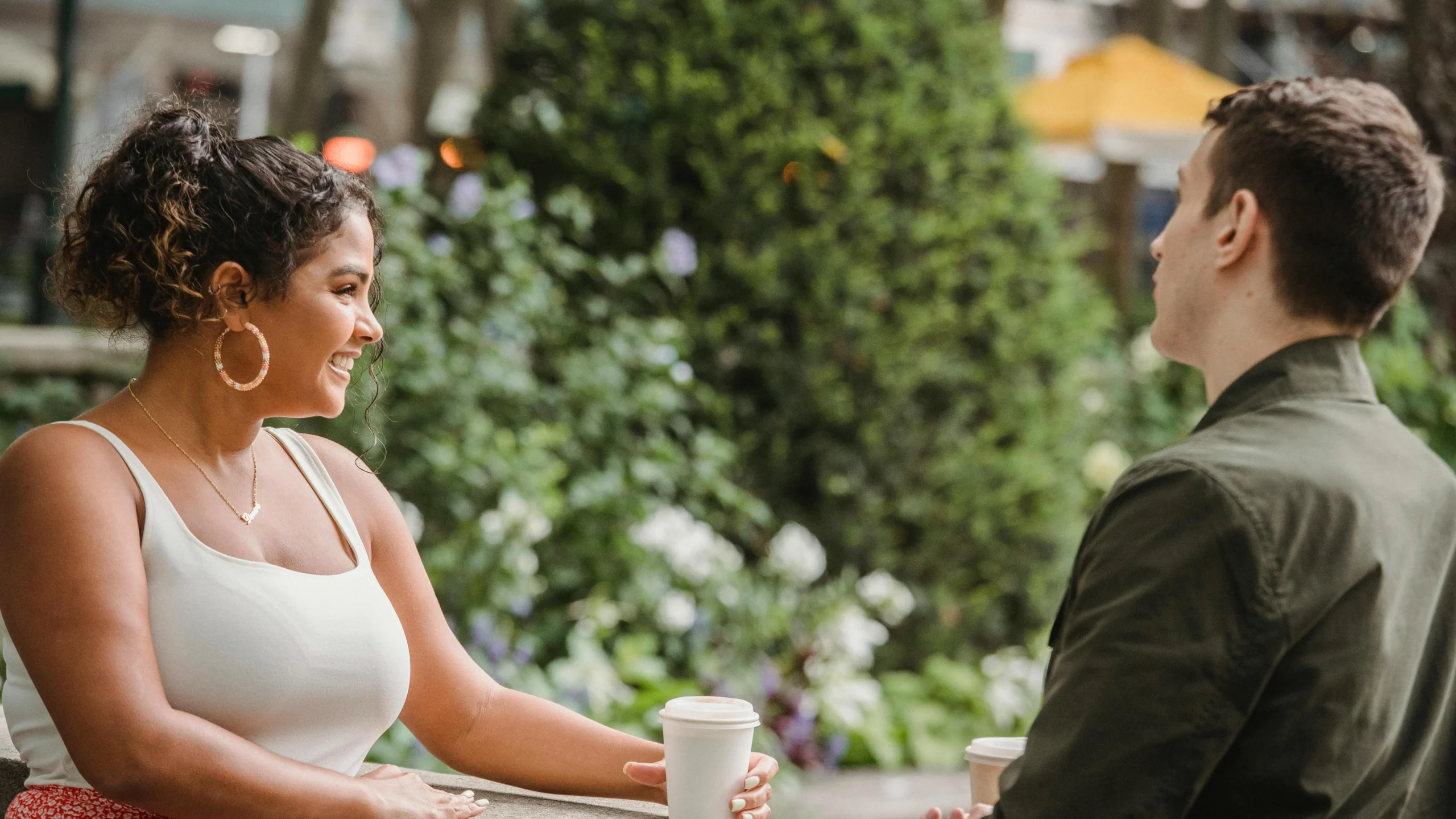 Cheerful couple enjoying coffee break together, representing cosmetic dental enhancements benefits.