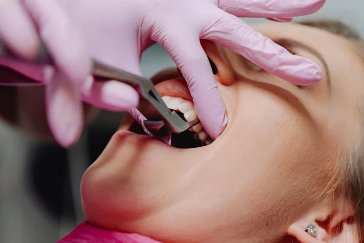 Dentist with pink gloves providing pain-free dental experience to a woman