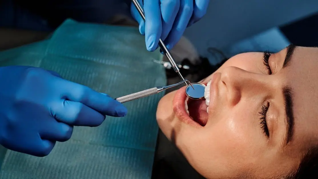 Dentist examining a woman's teeth to discuss implant dentistry cost