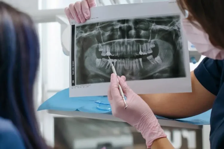 Dentist showing patient an X-ray for implant dentistry near me