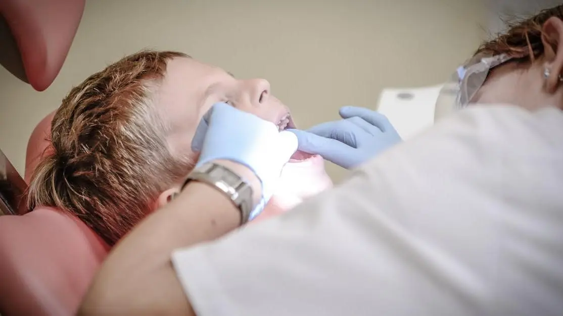 Kids dental specialists examining young boy's teeth