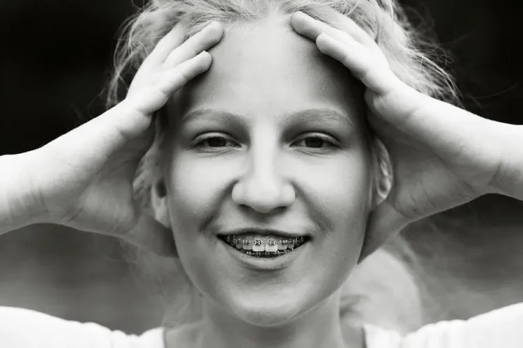 Smiling woman with braces, highlighting why adults get braces for improved dental health.