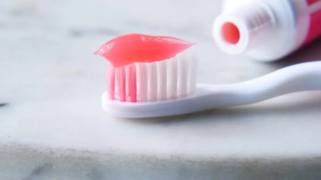 Toothbrush with toothpaste, highlighting baking soda vs toothpaste debate