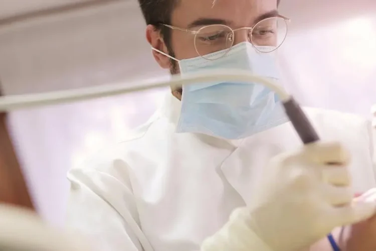 Dentist demonstrating benefits of fluoride treatments with dental tools