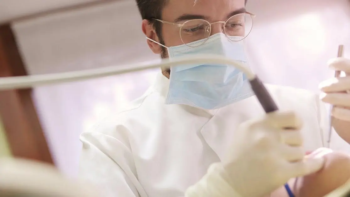 Dentist demonstrating benefits of fluoride treatments with dental tools