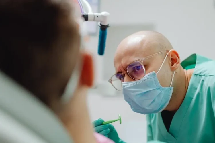 Deep sedation dentist examining a patient in a dental office.