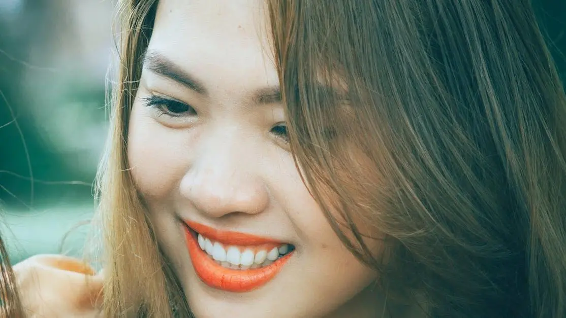 Smiling woman exemplifying best dental hygiene practices.