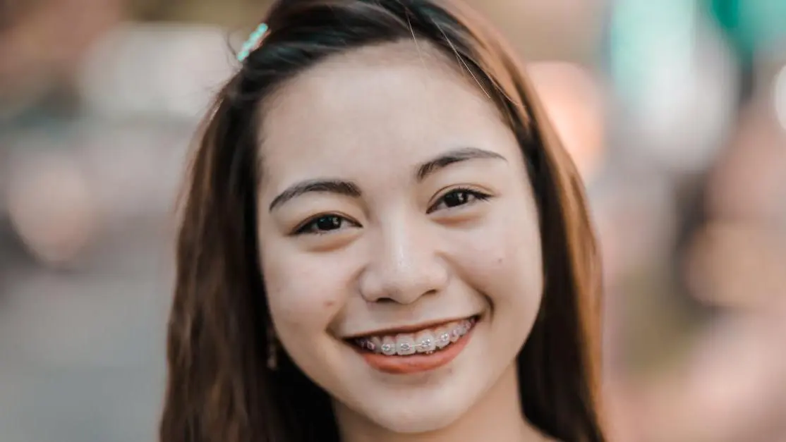 Smiling woman with braces practicing oral hygiene