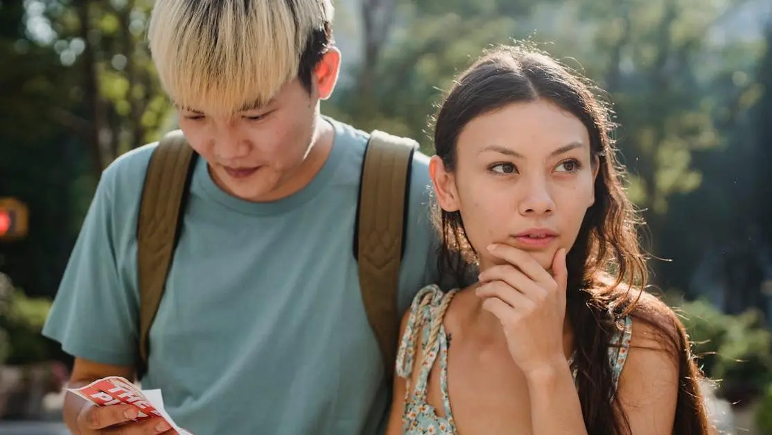 Couple comparing cash vs insurance dentist options on map during summer city exploration