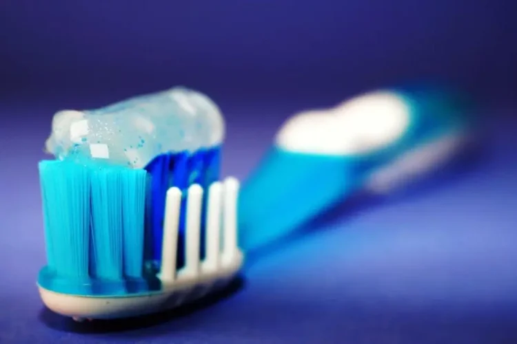 Toothbrush with toothpaste highlighting the issue of cavities despite brushing.