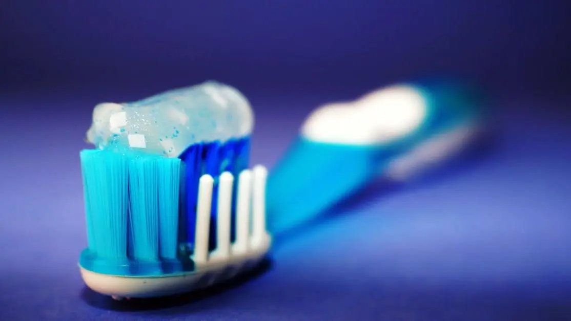 Toothbrush with toothpaste highlighting the issue of cavities despite brushing.