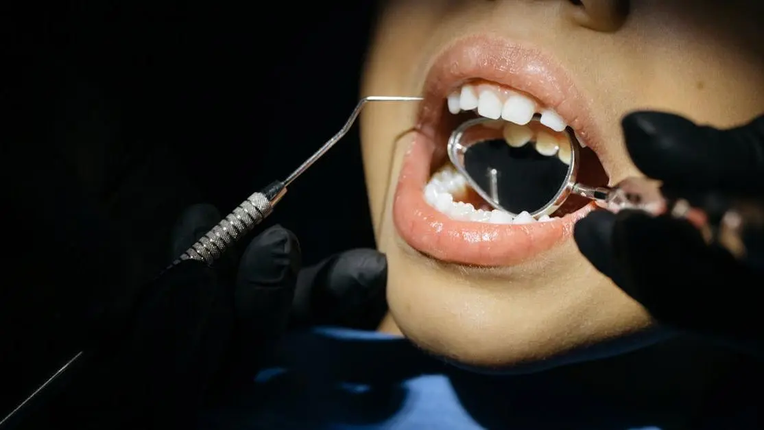 Child receiving dental checkup, highlighting when a child should start seeing a dentist.