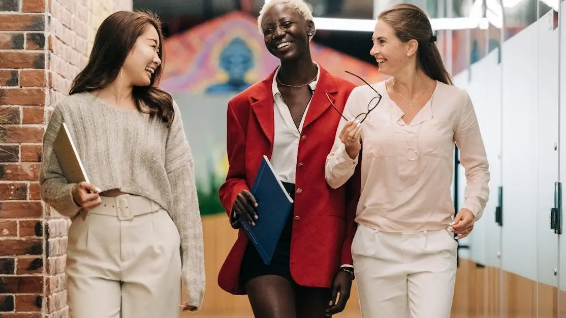 Young businesswomen in conversation, showcasing confident smiles and elegant style, related to cosmetic dentistry