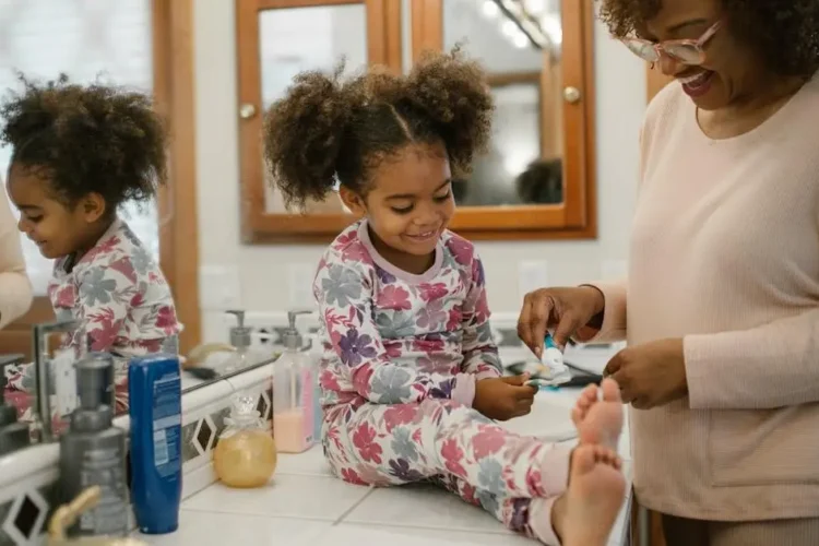 Mother and daughter practicing dental care, linked to cosmetic dentists near me.