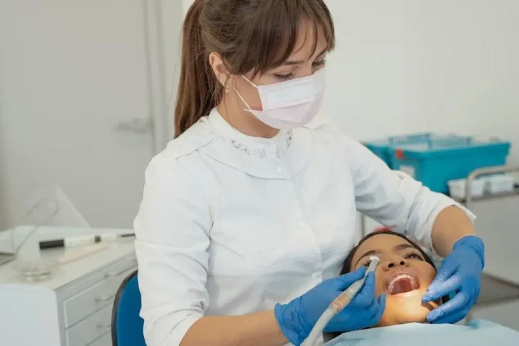 Dentist applying dental sealants to patient's teeth.