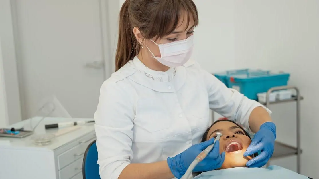 Dentist applying dental sealants to patient's teeth.