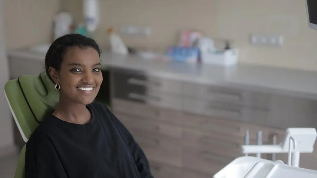 Young woman smiling in dental chair at clinic for dental sedation options