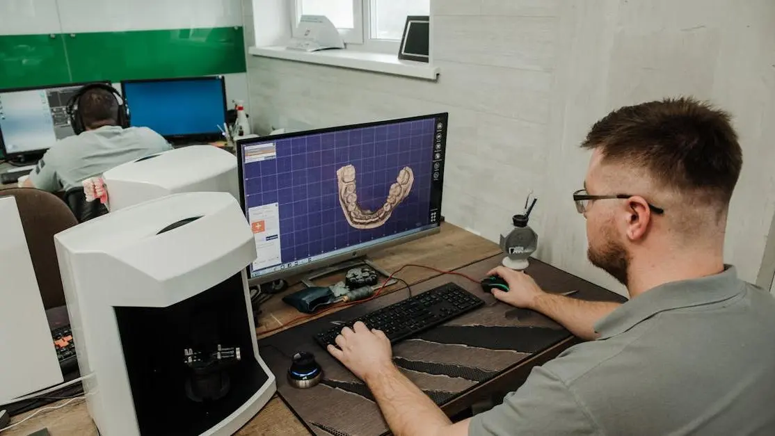 Male programmer creating 3D denture model in dental lab, showcasing digital impressions braces orthodontics.