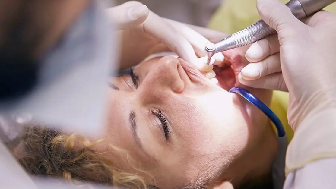 Dentist cleaning woman's teeth to prevent dry socket