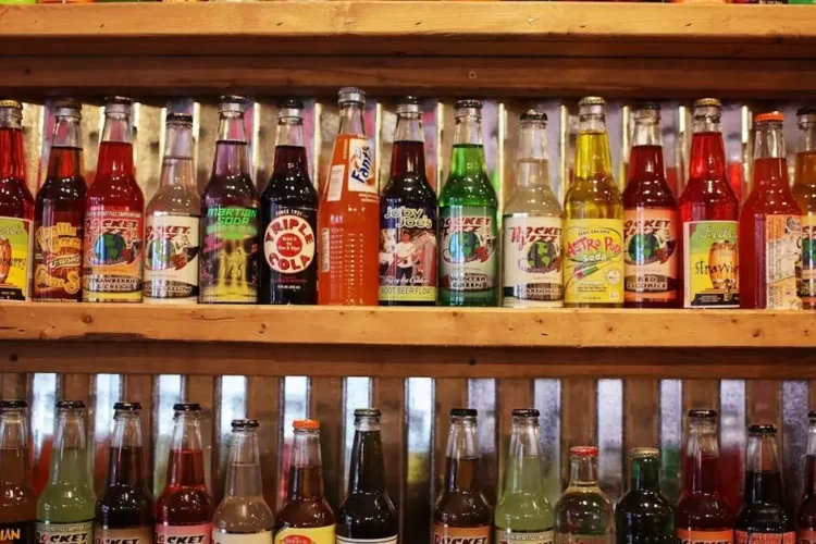 Colorful soda bottles on a shelf highlighting the effects of sugary drinks on teeth.