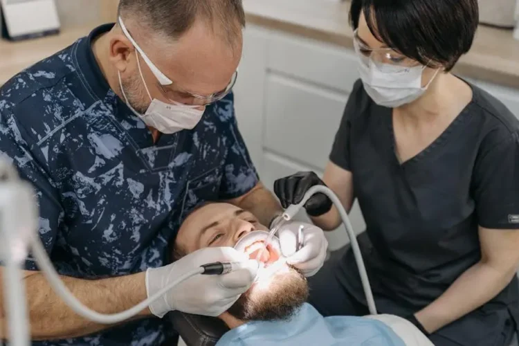 Dentist and assistant treating a patient in an emergency dental clinic