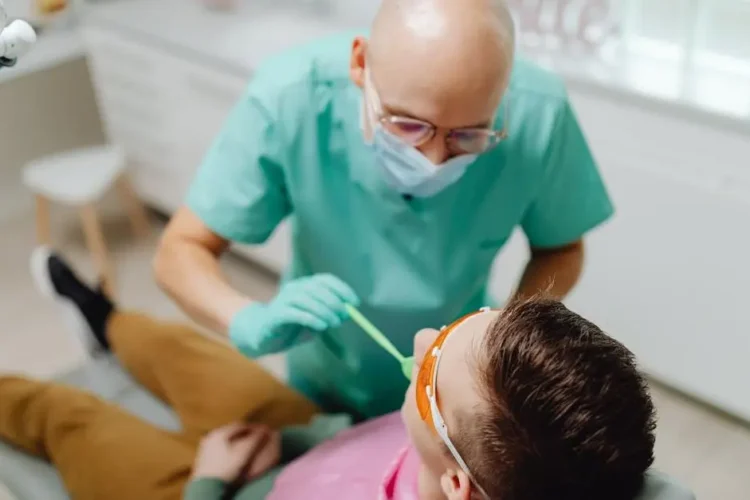 Experienced sedation dentist examining patient's teeth