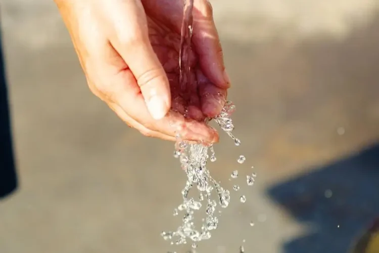 Hand under running water to improve dental hygiene.