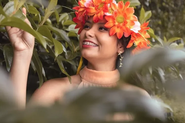 Smiling woman in orange floral headdress to improve your smile.