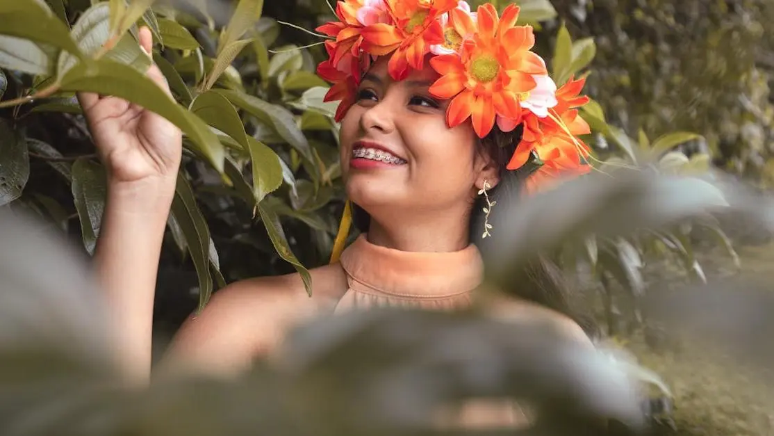 Smiling woman in orange floral headdress to improve your smile.