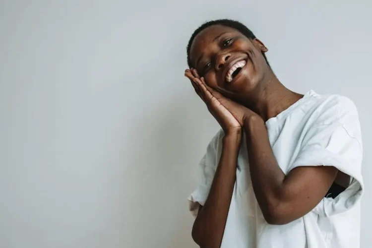 Smiling woman showing Invisalign clear aligners while leaning on her hands