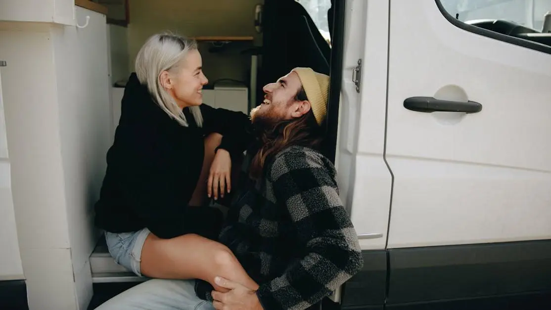 Happy couple sitting on a white van after visiting Invisalign dentists