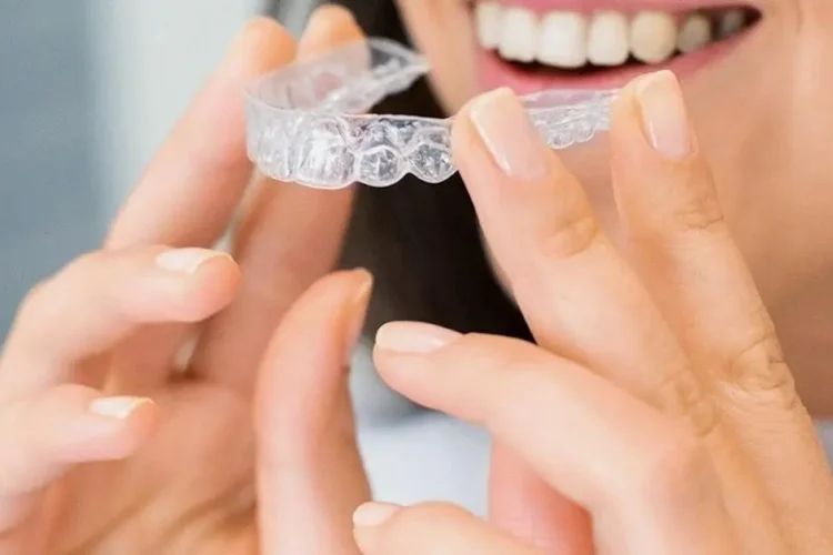 Woman smiling with Invisalign braces, highlighting expert care from Invisalign orthodontists