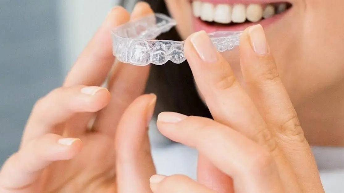 Woman smiling with Invisalign braces, highlighting expert care from Invisalign orthodontists