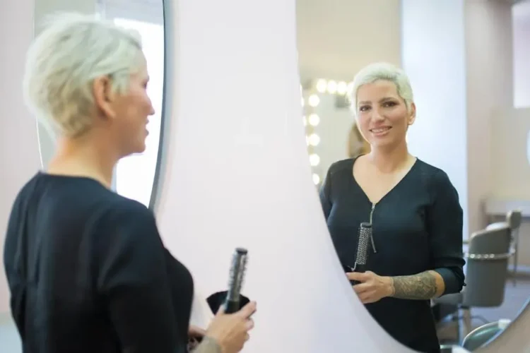 Woman admiring her Invisalign smile in mirror