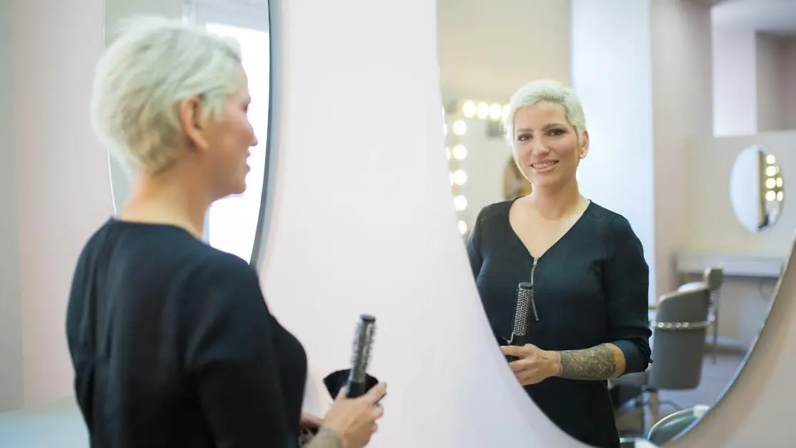 Woman admiring her Invisalign smile in mirror