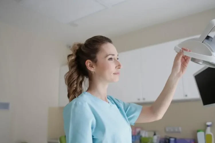 Medic adjusting lamp near computer, representing IV sedation for dental work awareness