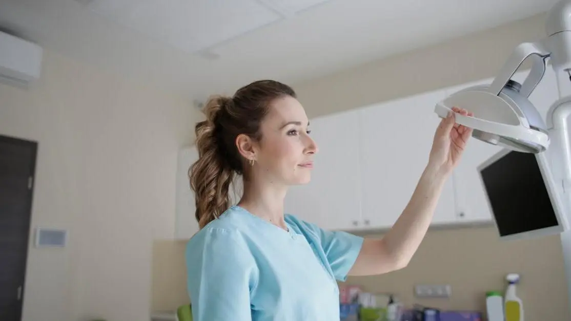 Medic adjusting lamp near computer, representing IV sedation for dental work awareness