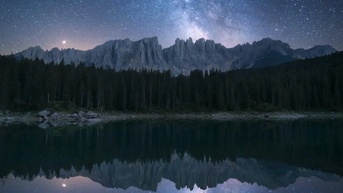 Night guard benefits: peaceful sleep under starry sky, pine trees and serene lake backdrop.