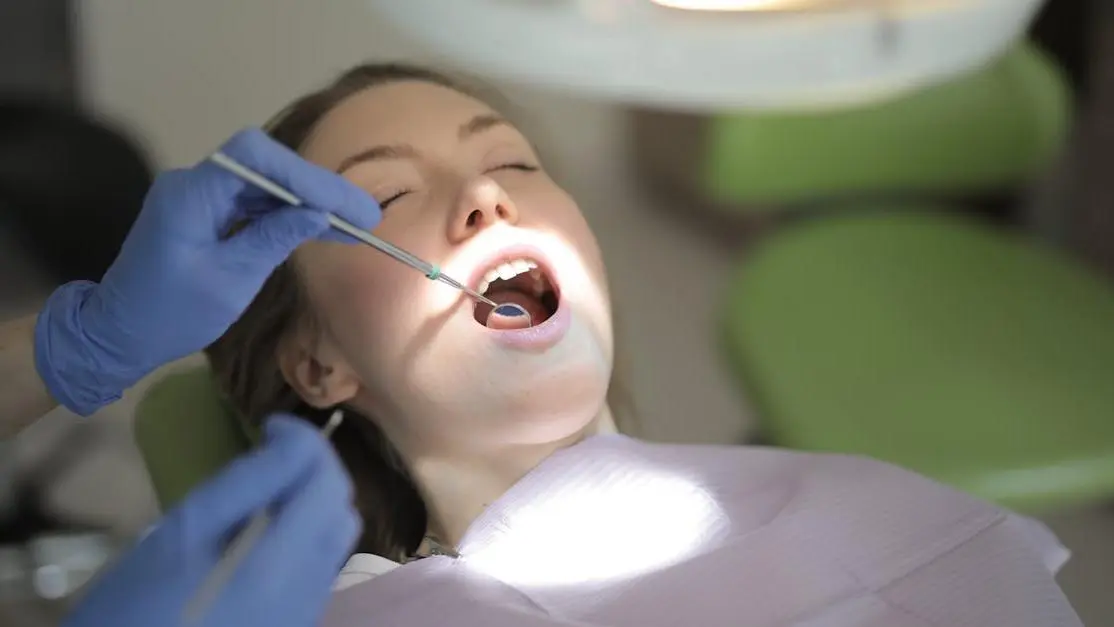 Dentist examining patient's teeth for oral cancer symptoms in clinic