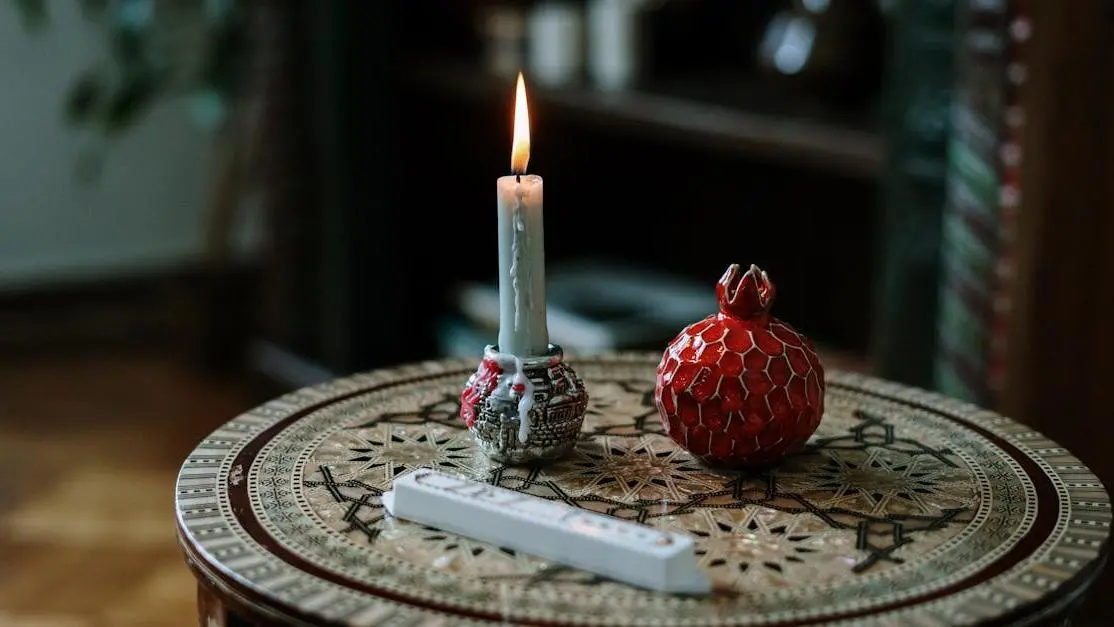 Festive table with candle and ceramic pomegranate; oral health tips tricks holiday season.