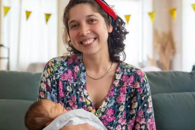 Smiling woman on couch, representing pain-free dental experience.