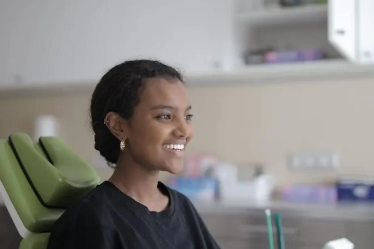 Smiling young woman experiencing painless dental procedures in modern clinic