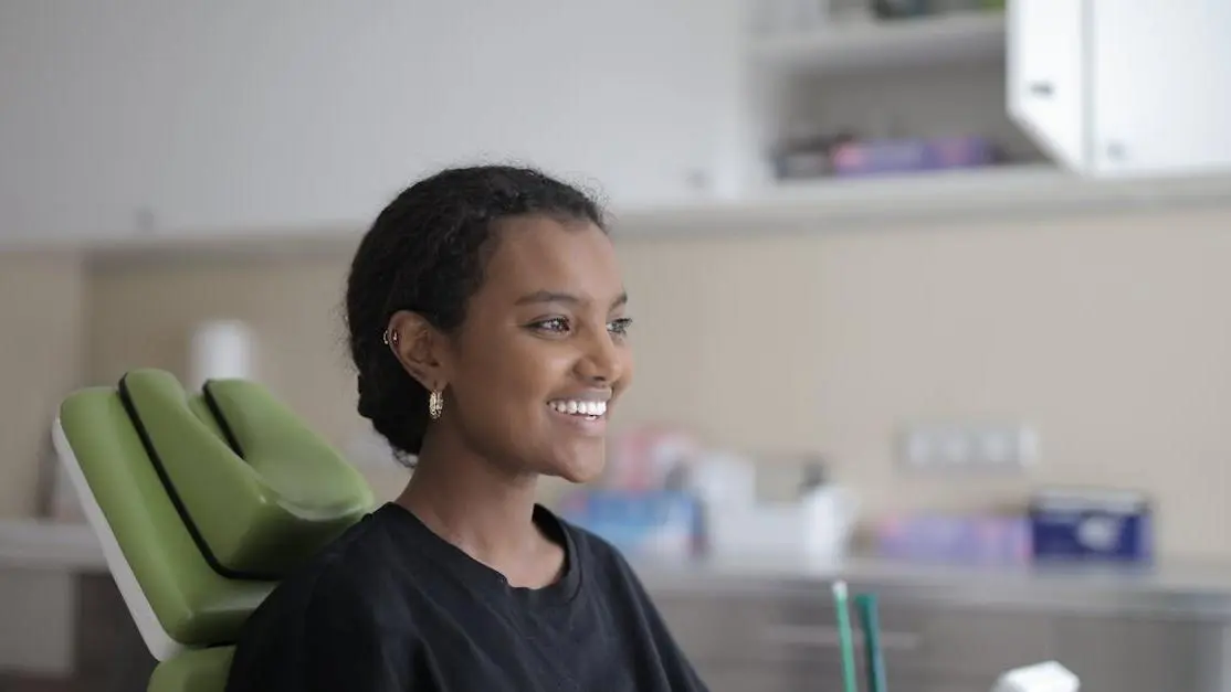 Smiling young woman experiencing painless dental procedures in modern clinic